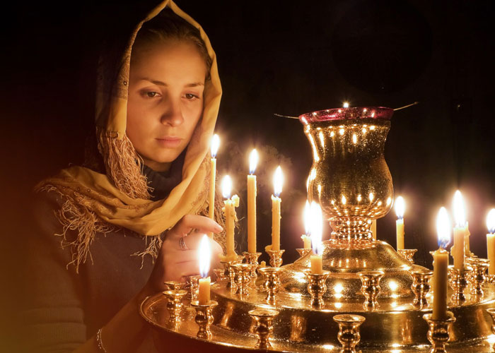 девушка в церкви у свечей
