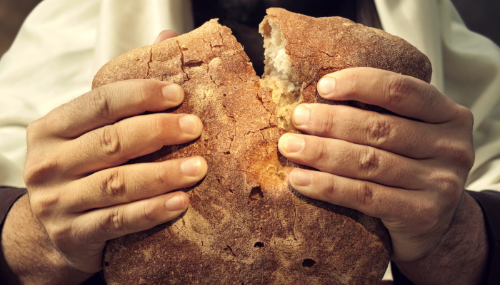 руки ломают хлеб