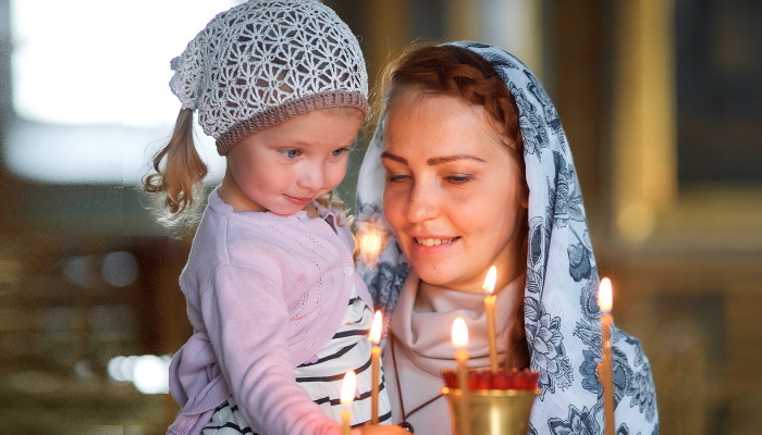 женщина держит ребенка, свечи, храм
