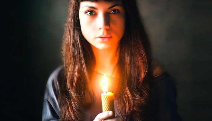 девушка со свечей в темноте